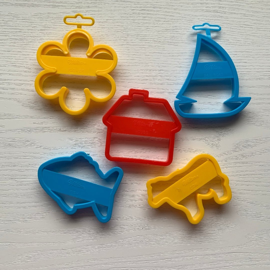 cookie cutters shaped like flower, boat, house, fish, and cow