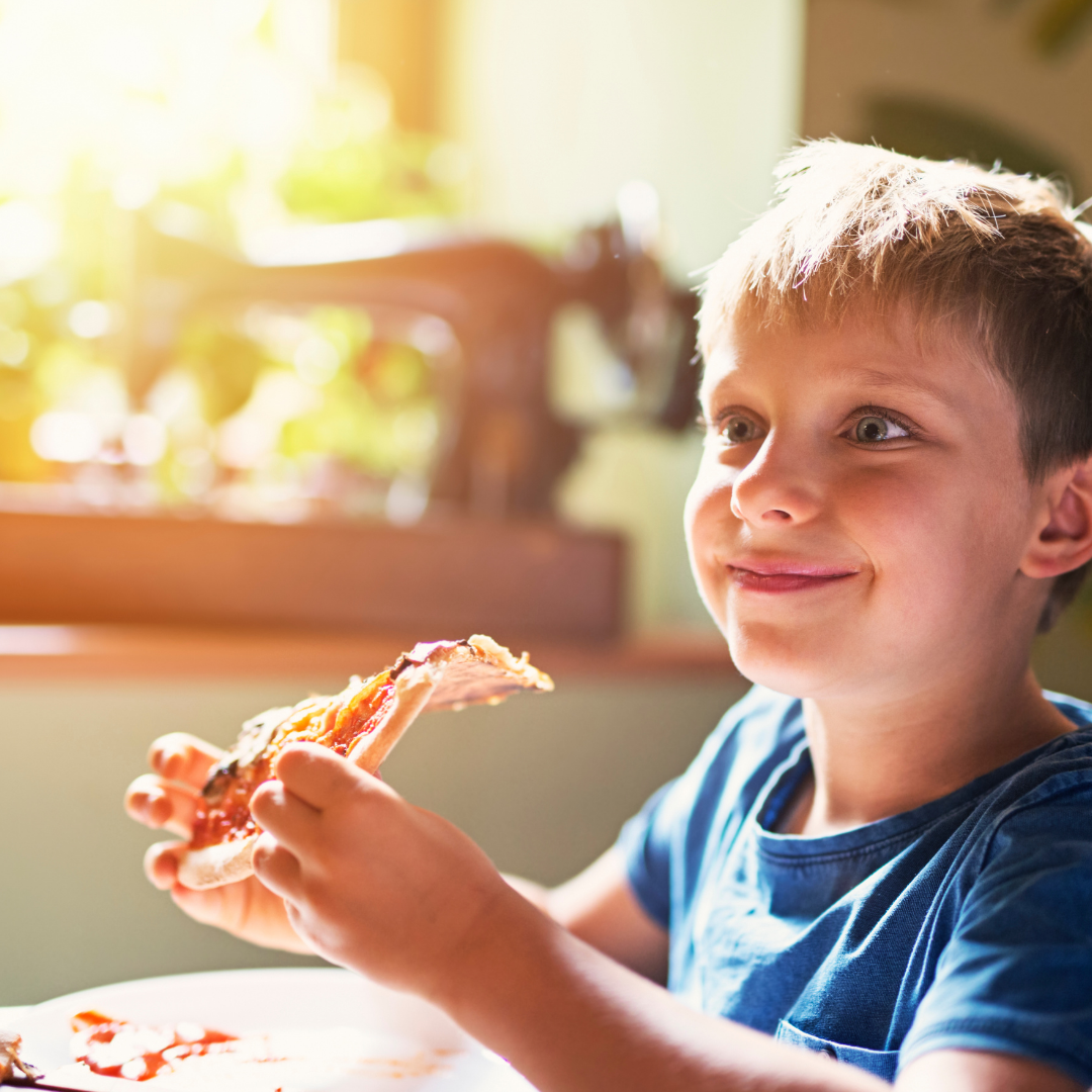 little boy eating pizza