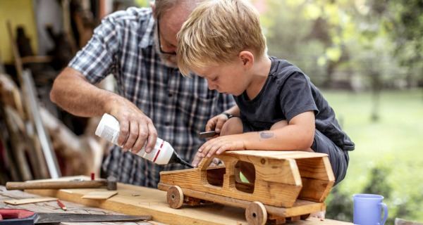 grandfather-and-grandson-making-a-car-from-wood-picture-id1168193290