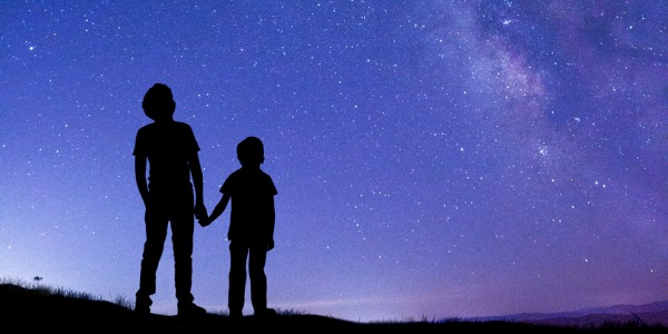 two-boys-looking-at-milky-way-picture-id1395331230